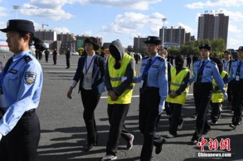 资料图：警方从广州用大巴车将275名电信诈骗犯罪嫌疑人押解回吉林省。张瑶 摄