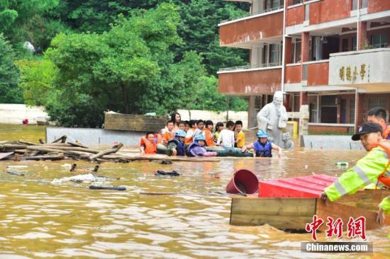 6月9日至10日，江西省龙南县普降暴雨，该县地势低洼的杨村镇中心小学师生被洪水围困。危急时刻，当地迅速组织武警、消防等力量奔赴救援。由于橡皮艇有限，不少救援人员让学童们骑在自己肩上，加快撤离被洪水围困的学校。截至10日17时，该小学1309名师生全部安全转移。文/叶波 王剑 图/叶波